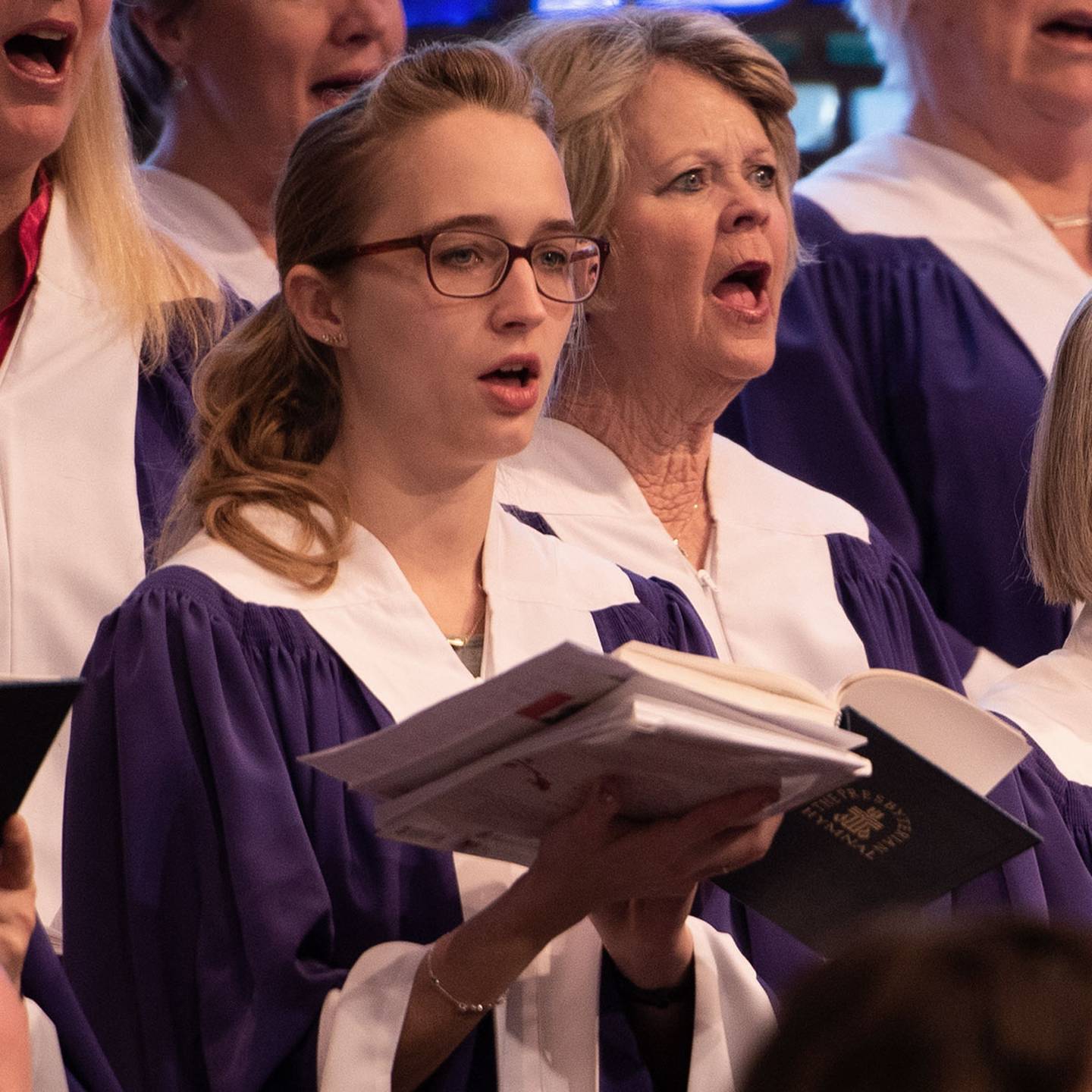 Close up of a woman in a church choir singing.