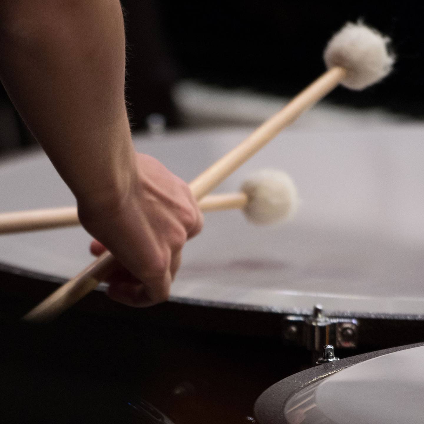 Close up of mallets beating a timpani.